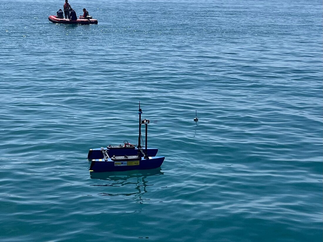 The real BlueBoat ASV in open water during a field test, with a small buoy nearby